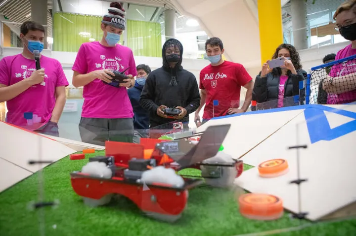 Bernard Zoungrana ('24), center, drives his robot during the finals of the Turf Wars robotics competition at the Science and Engineering Complex in Allston.