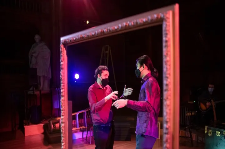 Benjy Wenzelberg (left) directs one of the actors on stage.