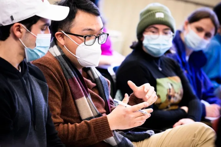 Student Charles Hua (second from left) asks a question in class.