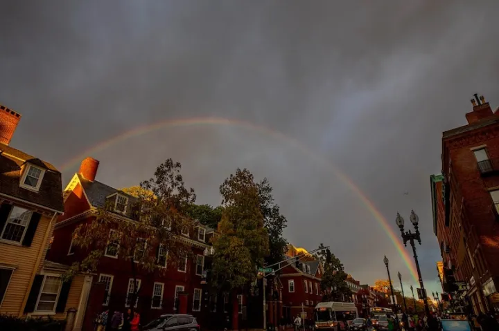 Landscape photo of Cambridge with a rainbow in the background.