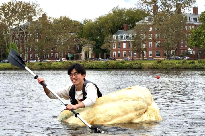 Benjamin Chang rows a hollowed-out 1,500-pound pumpkin across the Charles River.