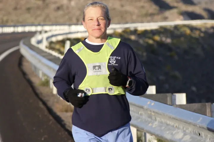 Physics Professor Jenny Hoffman running on the edge of a high way. 