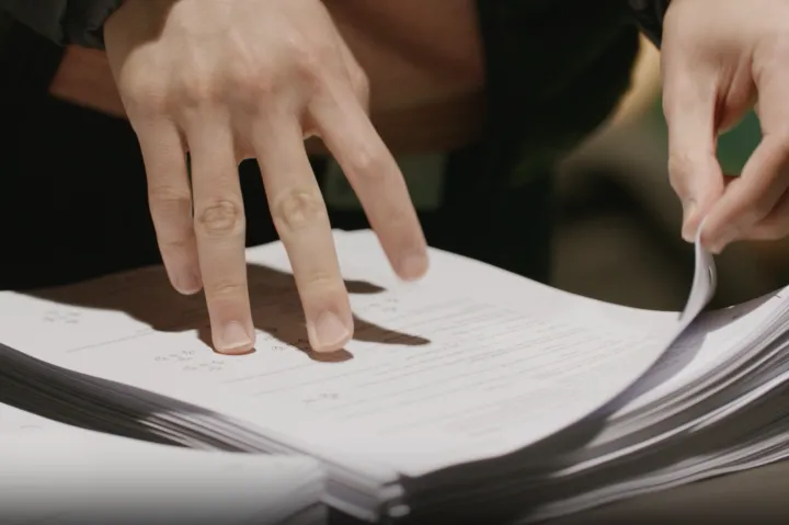 Close up photo of Student picking up packet of papers