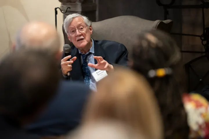 Historian Dick Ryerson sitting and speaking to a sitting crowd