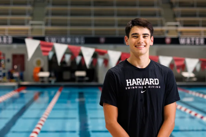 Harvard College Senior Nicola Hensch smiles next to a pool at Harvard's athletic facility.