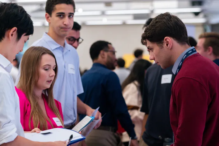 A group of young professionals having a conversation at a busy networking event