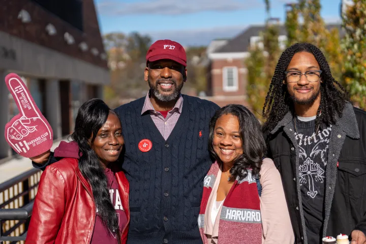A family of four smiles together for a photo.
