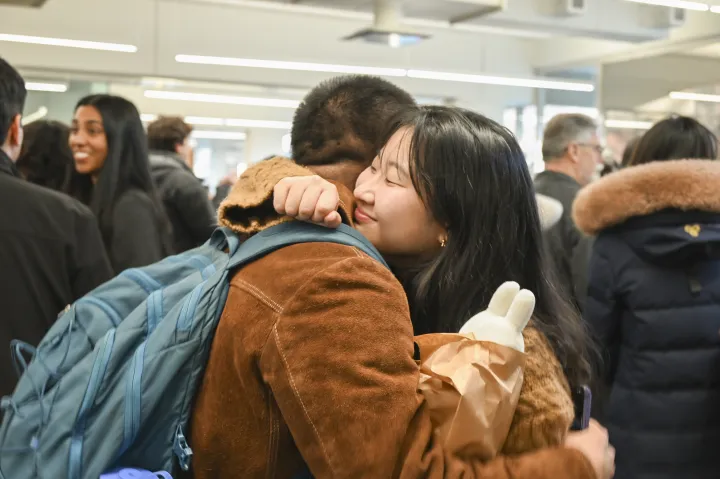 A student hugs her friend to celebrate her graduation.