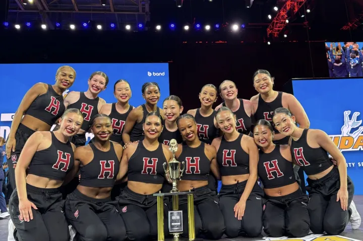 The Dance Team onstage crowded around their trophy.