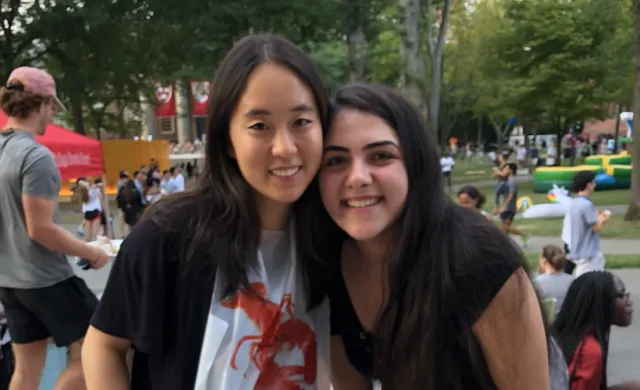 two students eating lobster in Harvard Yard