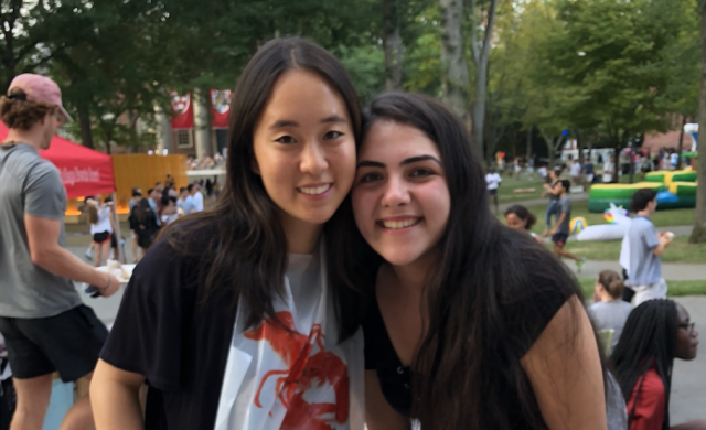 two students eating lobster in Harvard Yard