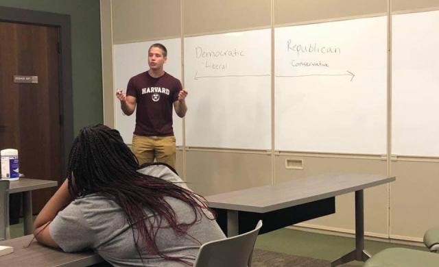 Student lecturing in front of a white board