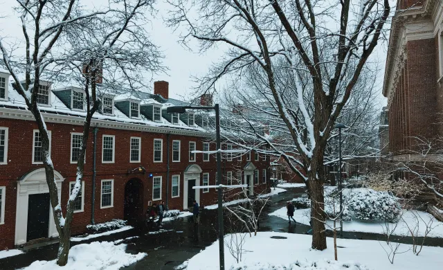 Snow falling outside brick dorm building