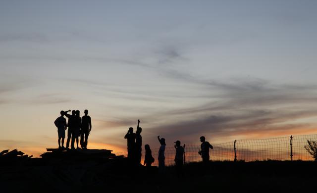 Silhouette of a group of people against a sunset background