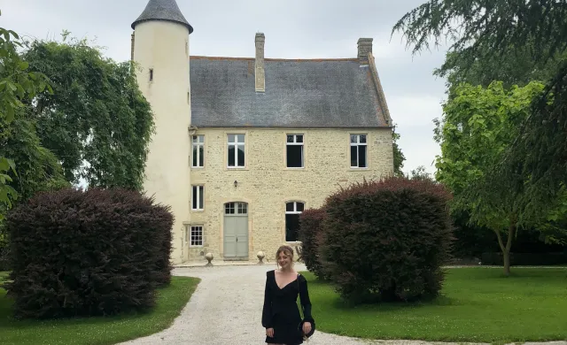 Malia at Chateau Monfreville, a castle in northern France, with greenery and sky in background