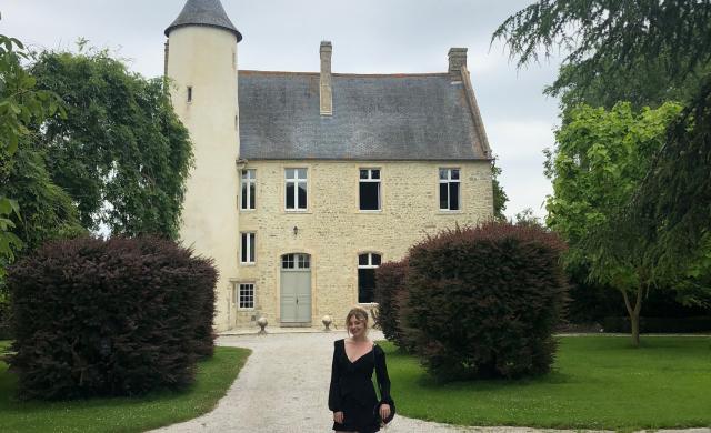Malia at Chateau Monfreville, a castle in northern France, with greenery and sky in background