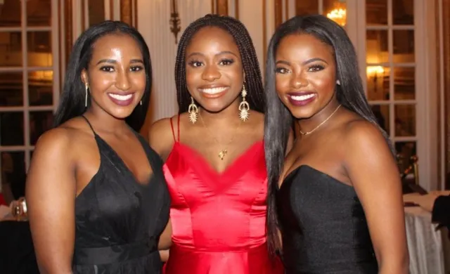 My two best friends and I, smiling, at a gala.