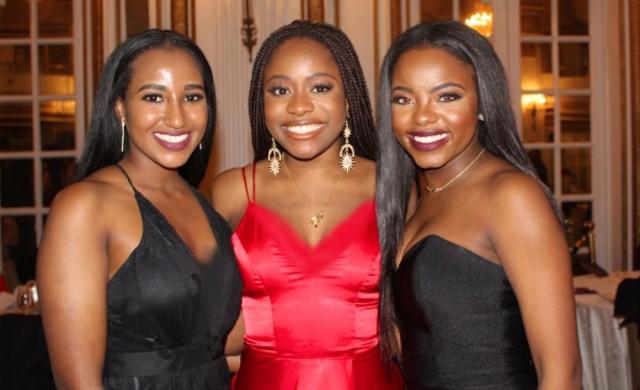 My two best friends and I, smiling, at a gala.