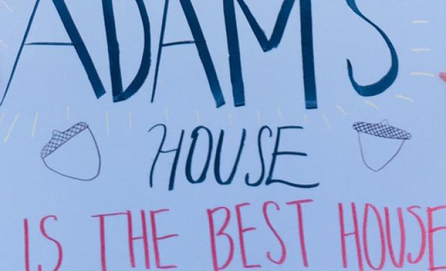 A picture of a white poster with "Adams House is the Best House" written on it.