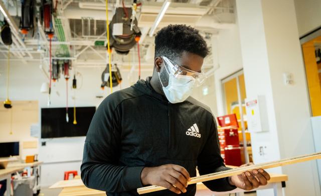 A person looking at a piece of wood