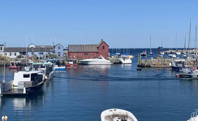 A red farmhouse surrounded by water and boats.