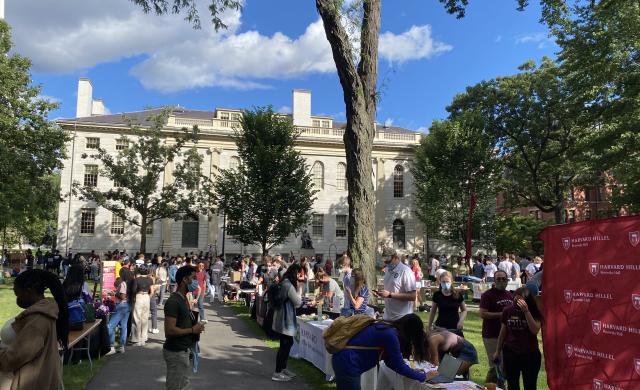 Large number of students walking around a fair that is dedicated to exploring clubs at Harvard