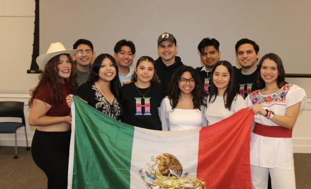 An image of the 11 board members for RAZA of the 2023 year.  They are holding up a Mexican flag. 