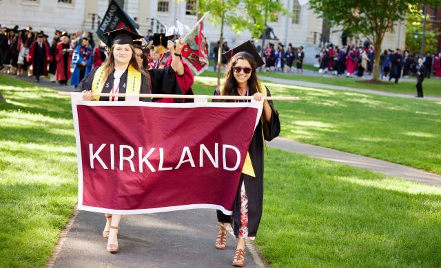 Hannah and a friend carry the Kirkland House banner at Commencement.