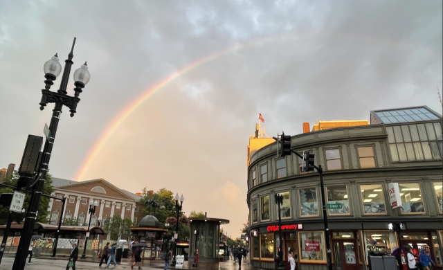 Rainbow at dusk over the Harvard MBTA subway station right after a rainstorm.