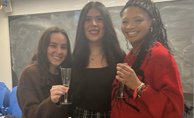 Three girls smiling for a picture. 