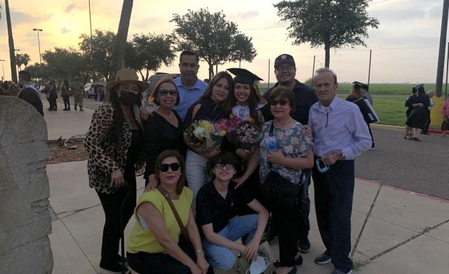 Ana with her family member at her high school graduation.
