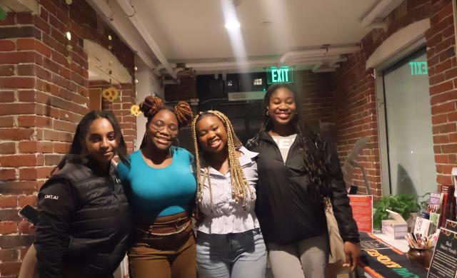 A picture of four black girls smiling and posing for a picture 