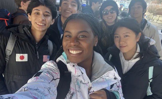 Group of students take a selfie in ski gear.