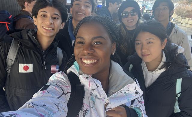 Group of students take a selfie in ski gear.