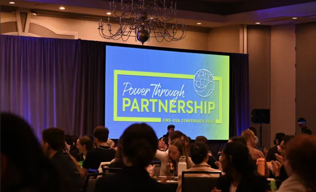 Slide with a blue background and green letters spelling "Power Through Partnerships."