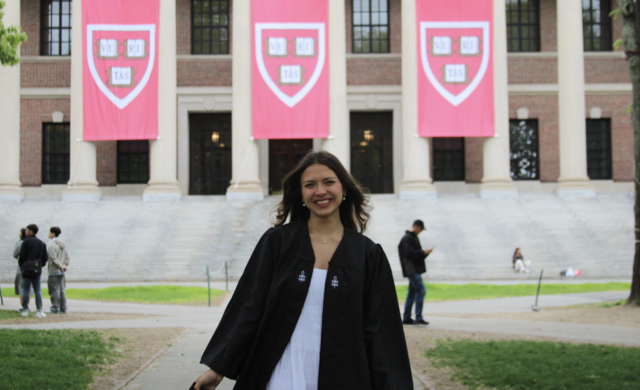 Ana posing in front of the Widener library in her graduation regalia. 