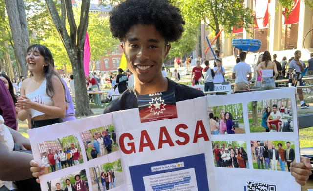 Ricardo holding up a poster board during the student activites fair
