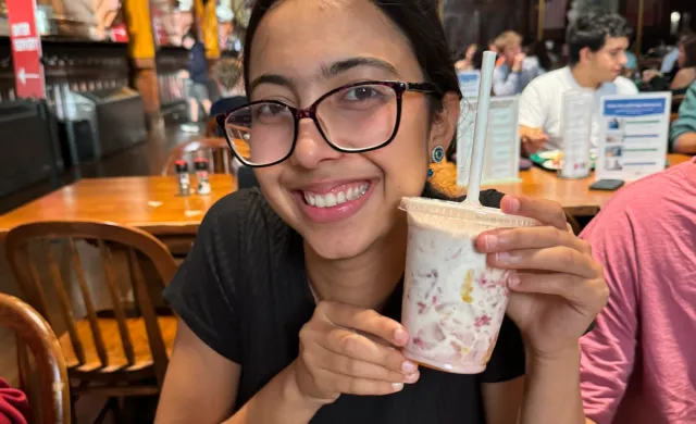 Meena holding up her created drink at Berg