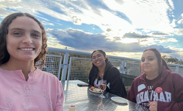 Secquoia, mom and older sister sitting on terrace outside 