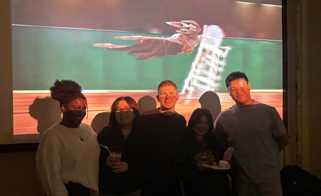 5 people standing in front of a projector screen.