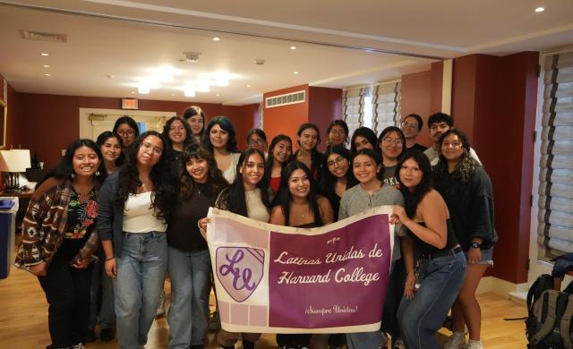 A group of students holding a Latinas Unidas de Harvard College banner. 