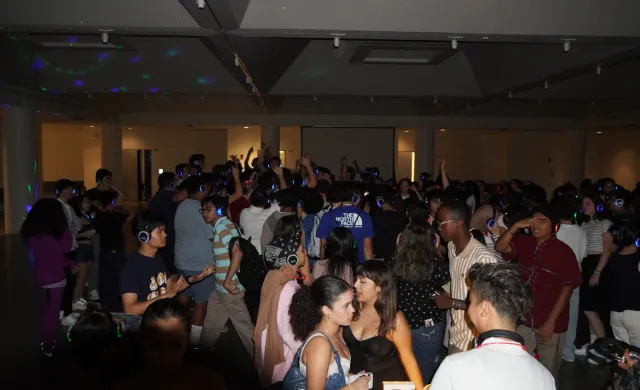 students at a silent disco, with lit up headphones