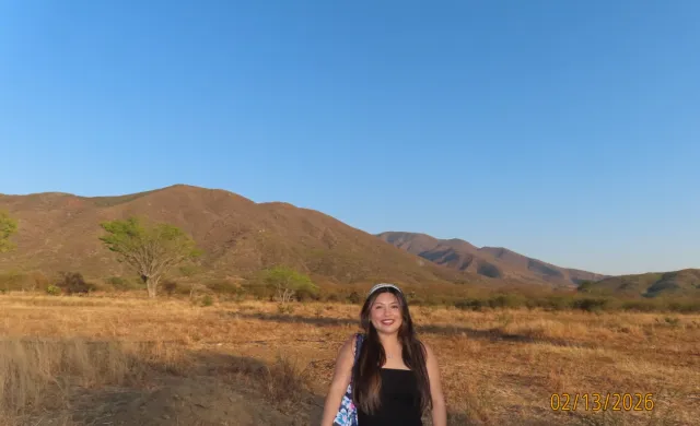 Person in front of mountain range. 