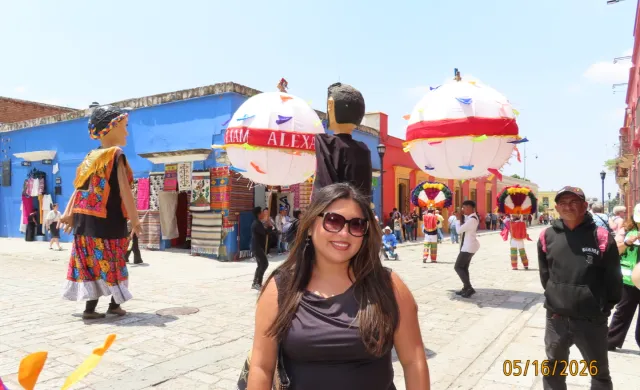 Daisy in front of a calenda which is a jubilant Oaxacan street party