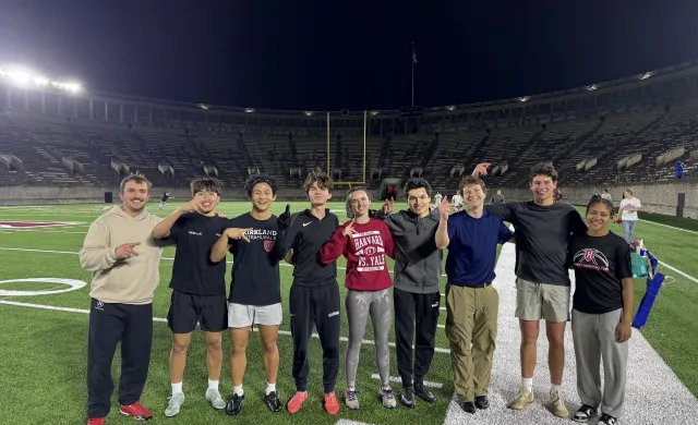 A diverse group of student athletes pose for a photo holding up the asl sign for "K" to celebrate Kirkland's victory.