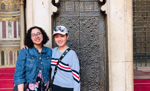 Two students in front of a mosque