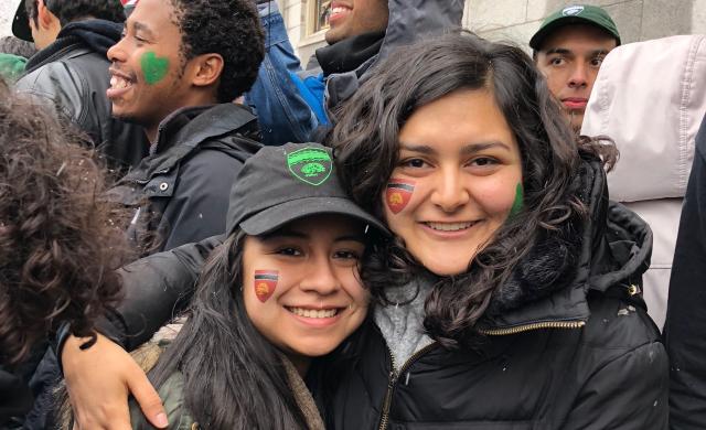 Maria posing with one of her friends who also lives in Currier. They are outside and it is snowing. 