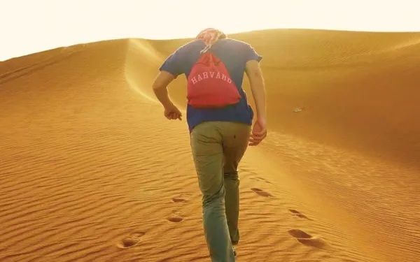 Student with Harvard backpack in desert