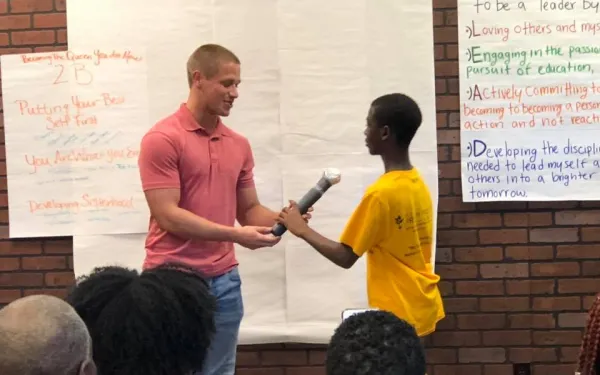 Two Students holding a microphone
