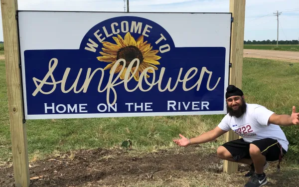 Picture of Harpreet next to the Sunflower County Sign